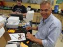 TI class participant Bill Hunt, a computer teacher, works on one of the class's hands-on projects. In the background is geometry and algebra teacher Kevin Horack.